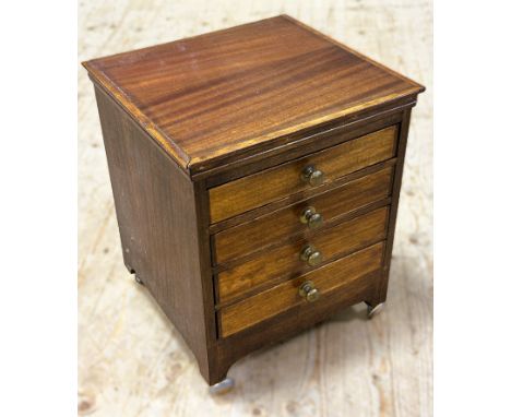 A mahogany miniature collectors chest with four fitted drawers and brass knob handles on bracket feet and ball style casters 