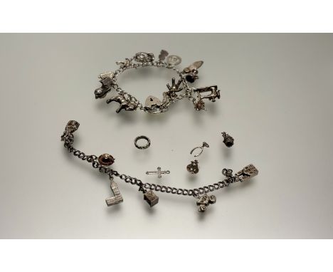 A silver chain link bracelet with a heart-shaped padlock with a collection of thirteen charms to include a teddy bear, a pony