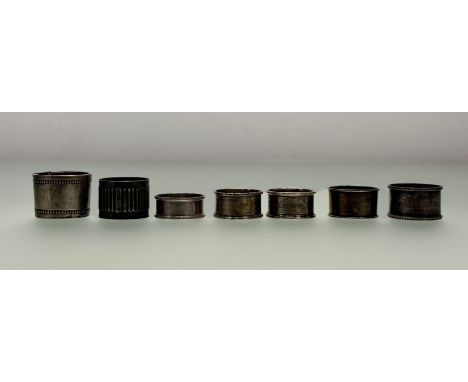 A collection of four various Birmingham silver napkin rings, a Chester silver napkin ring, a London silver napin ring and a D