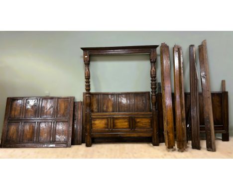 A 1900s/1920s oak four poster Tudor style bed complete with panelled back and sides and turned columns to footboard with mode