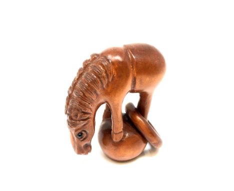 A Japanese carved hardwood netsuke : Horse with Hoop. 
