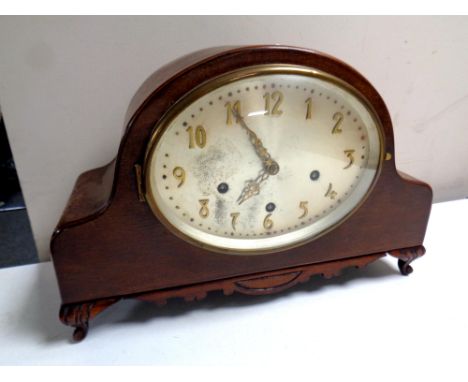 An Edwardian mahogany cased mantel clock with an oval silvered dial  