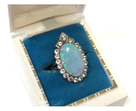 A vintage opal ring, set in Art Deco style with a border of white moissanite in yellow metal, head dimensions 26.82 mm x 16.6