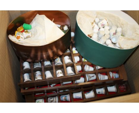 A LARGE COLLECTION OF CERAMIC THIMBLES CONTAINED ON WALL HANGING DISPLAY SHELVES 