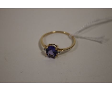 A HALLMARKED 9 CARAT GOLD TANZANITE RING, the oval tanzanite coming with a stone either side, and is approx 1.71 carats, meas