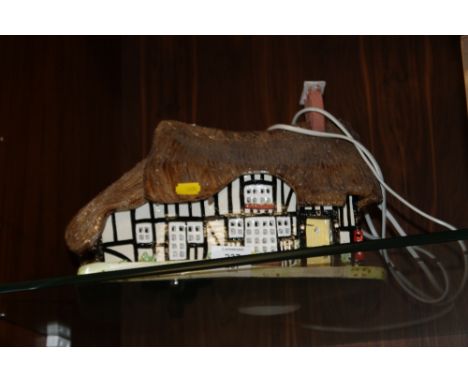 A CERAMIC TABLE LAMP IN THE FORM OF A THATCH COTTAGE