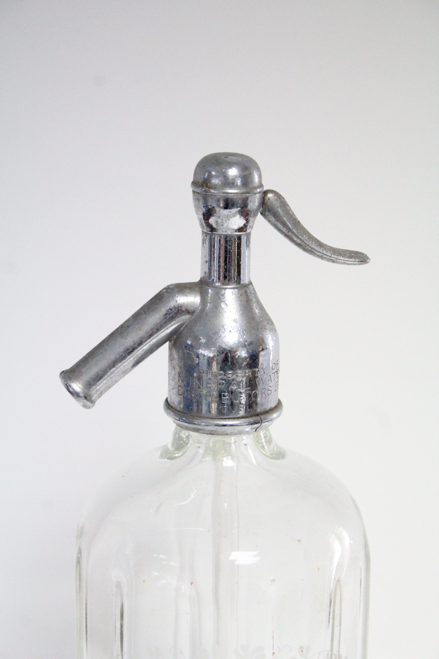 A mid20th century clear glass soda syphon bottle etched “MINERAL