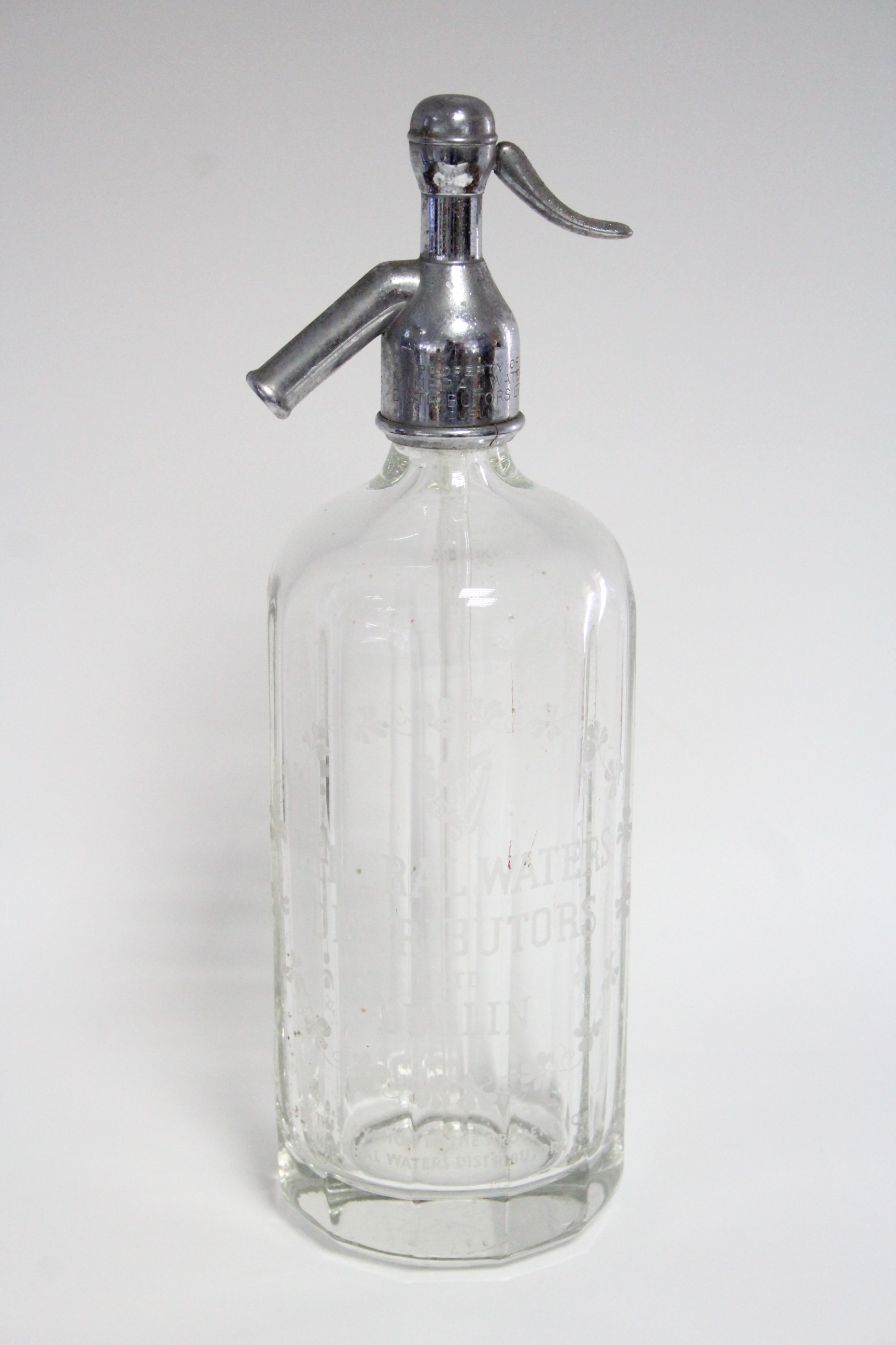 A mid20th century clear glass soda syphon bottle etched “MINERAL