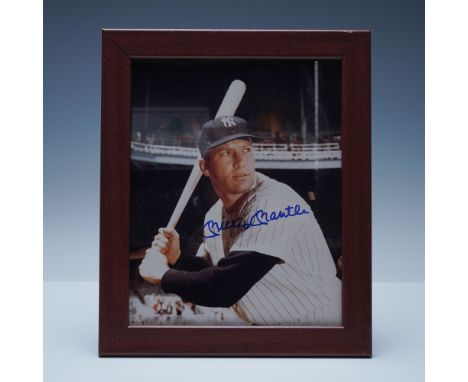 A framed photograph of baseball legend Mickey Mantle, signed in bold blue ink. This classic image captures Mantle in his icon