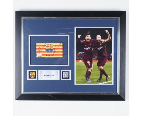 This framed and autographed FC Barcelona captain's armband display features the signatures of Lionel Messi and Andres Iniesta