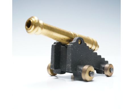 A finely crafted 1/4 scale model cannon, marked MFCO on the underside, featuring a solid brass barrel mounted on a rugged cas