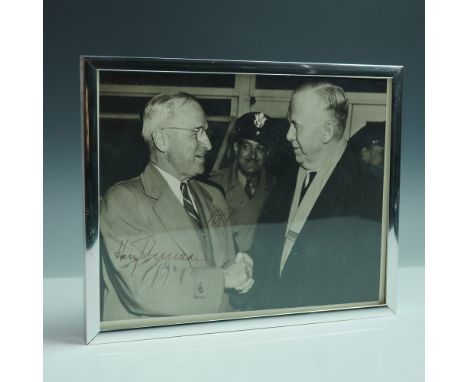 A remarkable vintage photograph capturing a moment of American postwar leadership, featuring President Harry S. Truman shakin