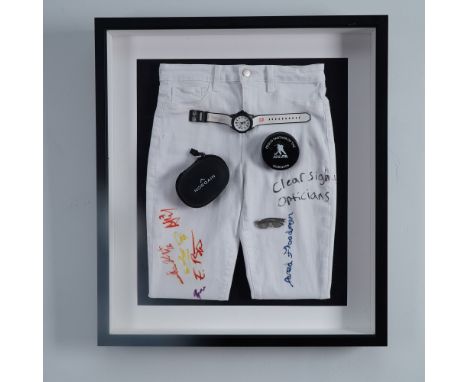 This unique sports memorabilia display features a pair of white jeans adorned with multiple team signatures, inscriptions, an