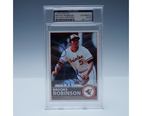 This PSA/DNA authenticated signed photo matte features Baltimore Orioles legend Brooks Robinson in action, inscribed "HOF 83.
