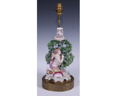 A 19th century figural lamp, moulded with a Cupid before bocage, shell and scroll base, 42cm overall