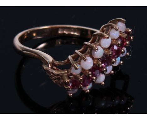 A 9ct gold ring, set with three bands of polished opal and faceted ruby stones, size L, marked 375, 2.5g