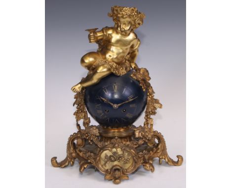 A Napoleon III ormolu and japanned mantel clock, cast as a Bacchic putto atop a celestial orb draped with fruiting vine, twin