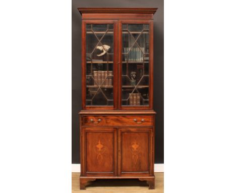 A Sheraton Revival mahogany and marquetry library bookcase, dentil cornice above a pair of astragal glazed doors enclosing ad