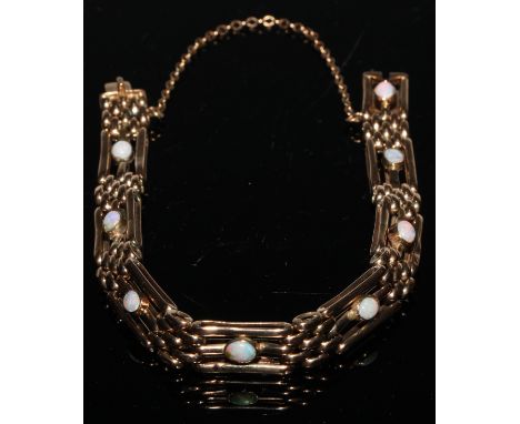 A 9ct gold gate bracelet, each of the eight three-bar panels centered with an oval cabochon opal, 14.3g 