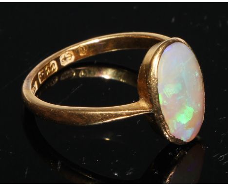 A 22ct gold and opal ring, the oval cabochon stone bezel set, plain shank, size M/N, 3.1g gross 