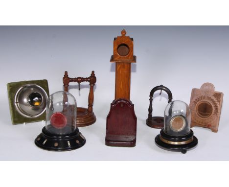 A 19th century ebonised pocket watch stand, glass dome, 16cm high, c.1870; another, similar; another, as a miniature longcase