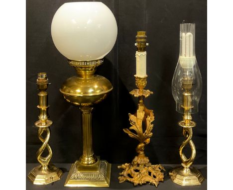 A rococo gilt metal side light, cast and pierced with leafy scrolls, 32cm high; a pair of brass candlestick side lights; a br