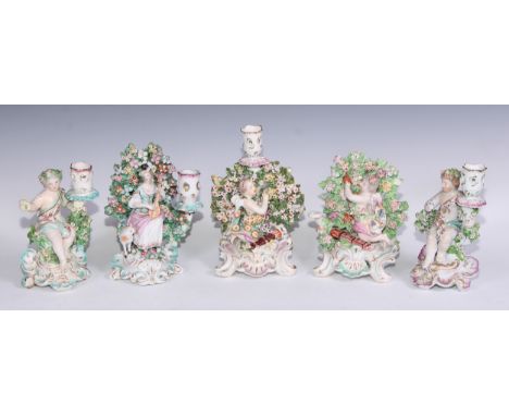 A Derby patch mark figural candlestick, modelled as Cupid kneeling before bocage, scroll and shell base, 22cm high, c.1770; o
