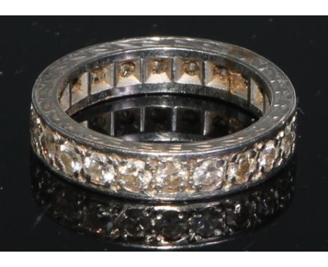 A diamond eternity ring, set with a continuous single row of brilliant cut stones, engraved white metal shank, unmarked, size