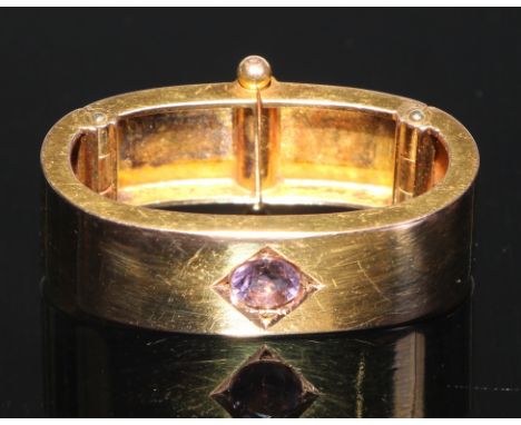 A 15ct gold oval scarf clip, quite plain, centered with a  single amethyst, 3cm wide, 6.1g gross 