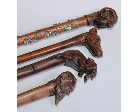 A novelty walking stick, the softwood handle carved as a dogs head and neck, 91cm long; another, the handle carved with a ram