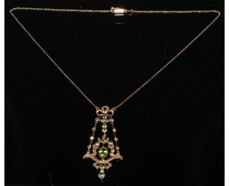 An Edwardian peridot floral ribbon bow pendant necklace, vibrant oval principle stone, twenty four smaller round cut accents,