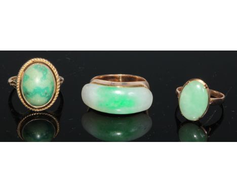 A 14ct gold and jadeite ring, set with an oversized curved rectangular panel, the mount and shoulders quite plain, size N; a 