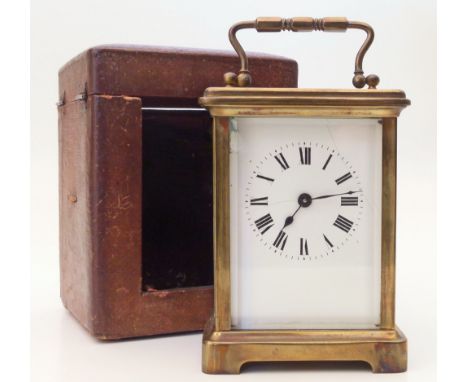 A brass carriage clock with white enamel face and Roman numerals. Single-train movement. With original leather presentation c