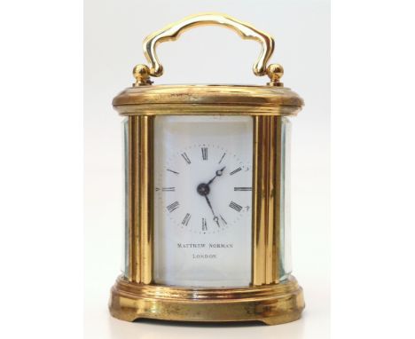 A small Matthew Norman, London brass carriage clock with curved bevelled glass panels to top and sides. 8 x 6 cm. Conditions 