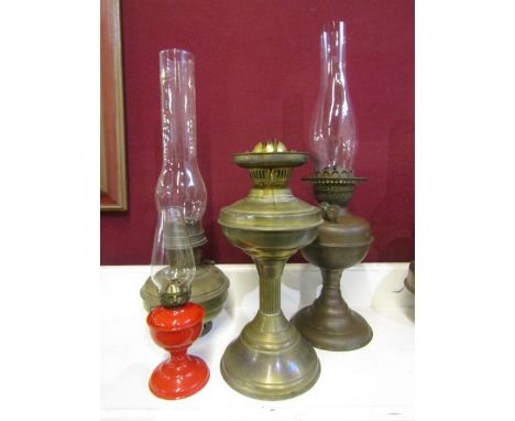 3 brass base oil lamps and a miniature red oil lamp