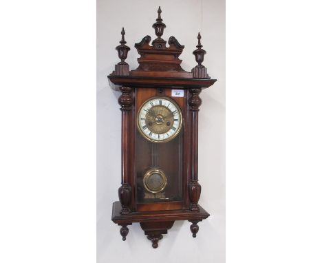 Early C20th continental Vienna style walnut cased wall clock, carved pediment with turned finials, over full length glazed pa