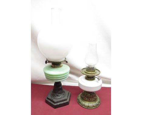 Early C20th oil lamp with opaque glass shade, opaline green tinted reservoir on cast metal base, H55cm, similar period oil la