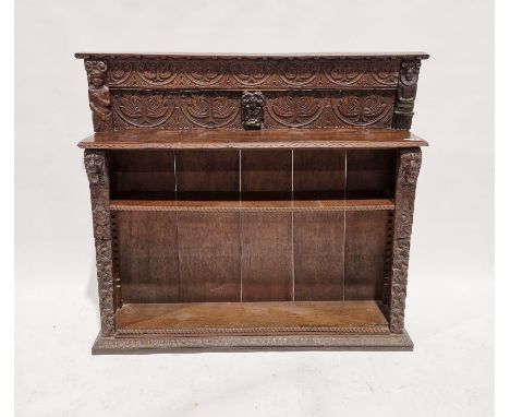 19th century carved oak bookcase, the raised back carved scrolled lunettes flanked by carved figures, the open base fitted on