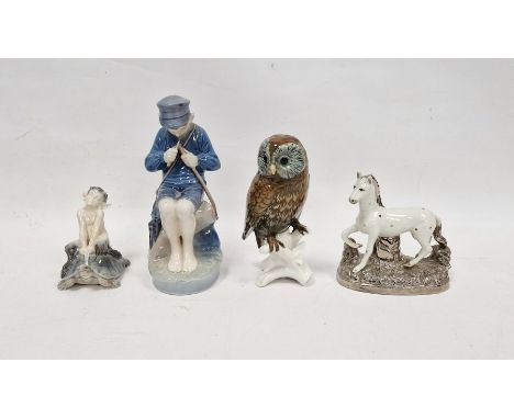 Royal Copenhagen model of a fisher boy, model no.079, seated on rockwork, on a shaped oval base, 18.5cm high, a model of a bo