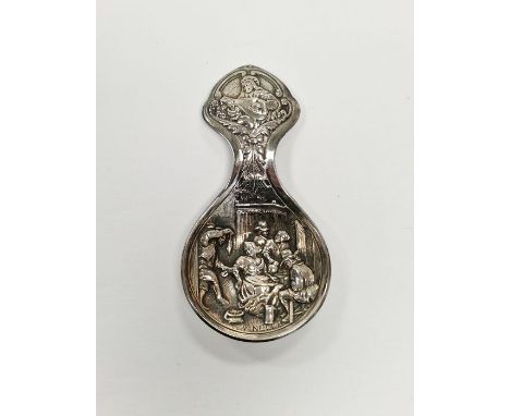 Continental white metal caddy spoon with embossed decoration depicting a traditional 19th century tavern scene, stamped 'Plee