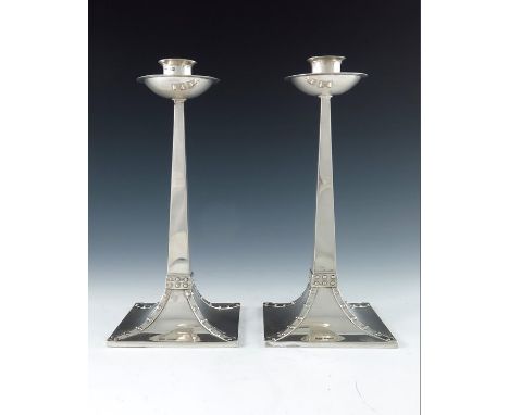 A pair of Arts and Crafts silver candlesticks, James Dixon and Sons, Sheffield 1916, square section tapered and splayed, embo