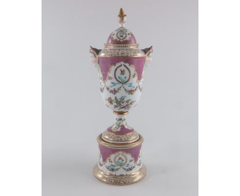 A Dresden vase and cover, twin handled pedestal urn form, on cylindrical plinth, decorated with Rococo style fish scale flame