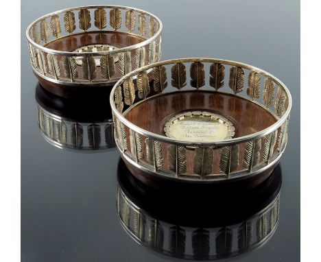 Hector Miller, a pair of Modernist silver gilt wine coasters, London 1981, reticulated galleries of ostrich feathers, on teak