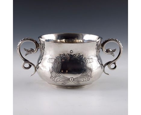 An Arts and Crafts silver twin handled bowl, Daniel and John Wellby, London 1906, planished squat baluster form with cast ser