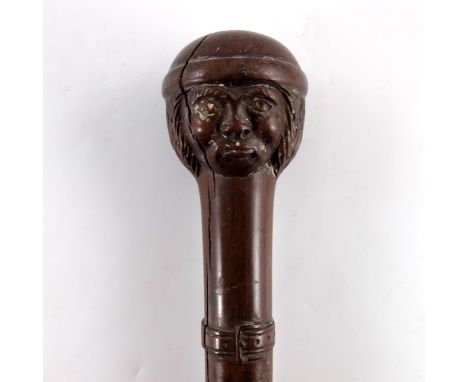 A 19th century tribal carved walking stick, the pommel modelled as a man's head, with rounded cap, above a belt, 87cm long