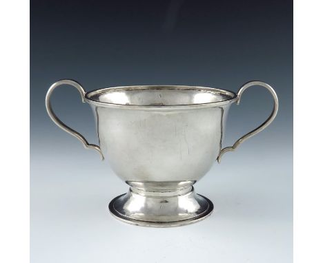An Arts and Crafts silver twin handled bowl, Central School of Arts and Crafts, London 1953, hand hammered footed form, with 