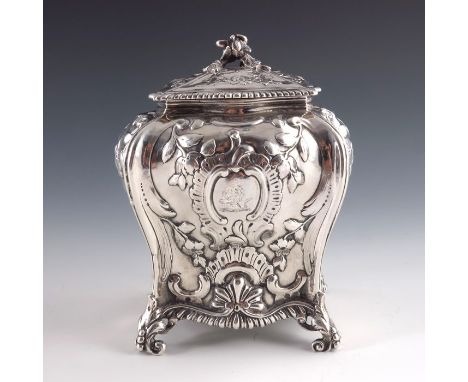 A George III silver tea caddy, Emick Romer, London 1765, of square section bombe form, embossed with Rococo shell and scroll 