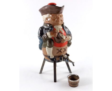 Harry Simeon for Doulton Lambeth, a spirit flask modelled as a Toby XX seated on a barrel, circa 1910 metal mounts and tap, w