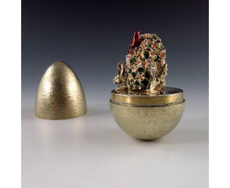 Stuart Devlin, a Novelty silver gilt surprise egg, London 1985, textured finish, opening to reveal an enamelled flowering shr