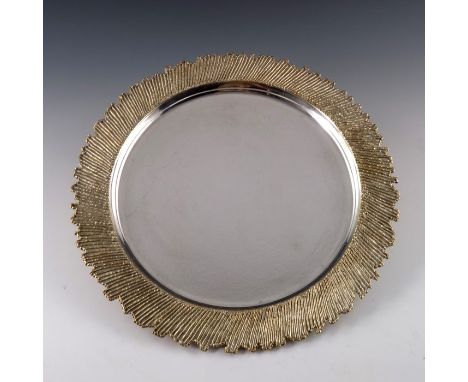 Stuart Devlin, a Modernist silver and parcel gilt drinks tray, London 1978, planished circular form, the wide brim of rustica